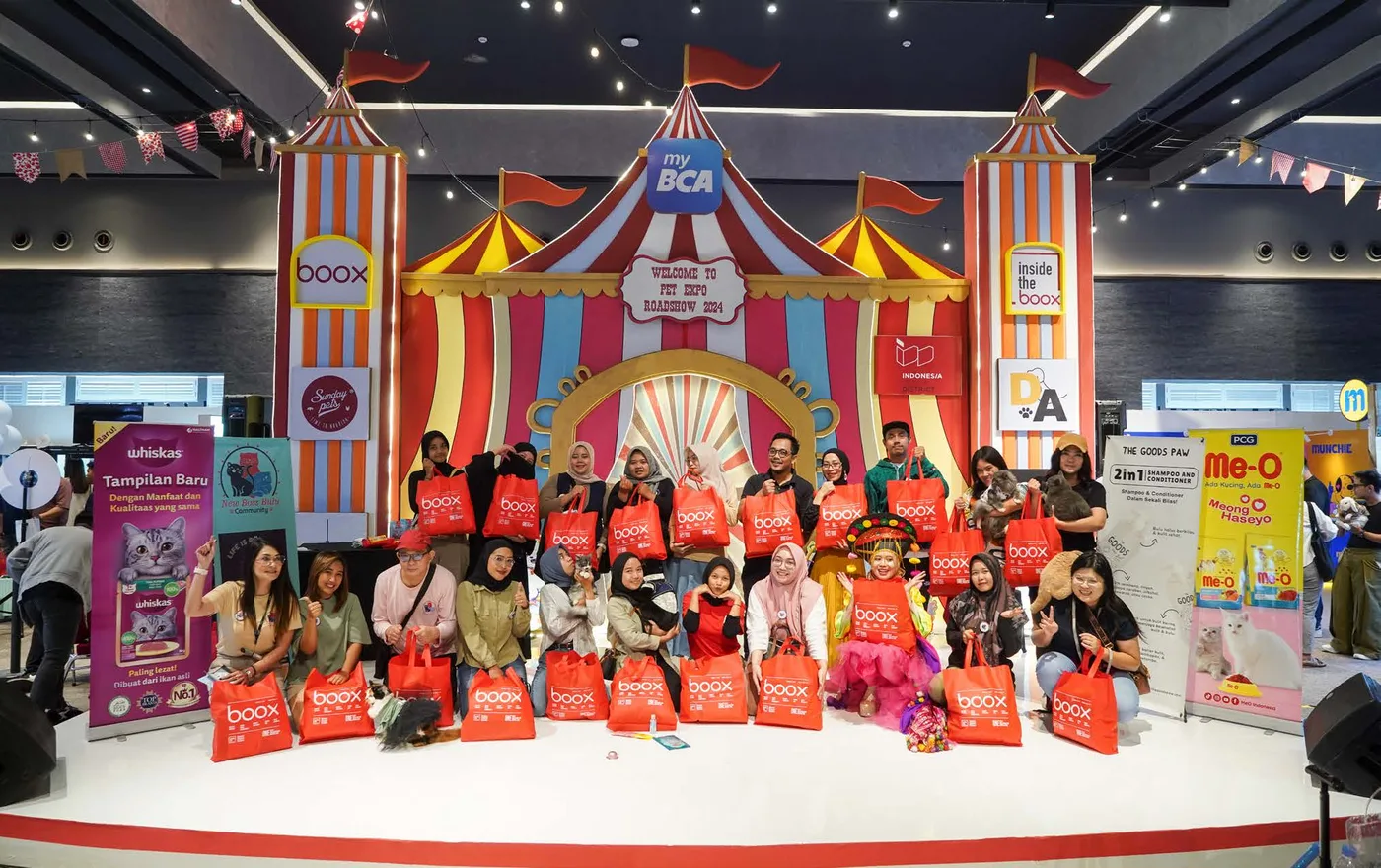 Instalasi tenda sirkus Pet Expo Roadshow 2024 dengan logo BOOX dan myBCA, pengunjung berbaris memegang tote bag BOOX